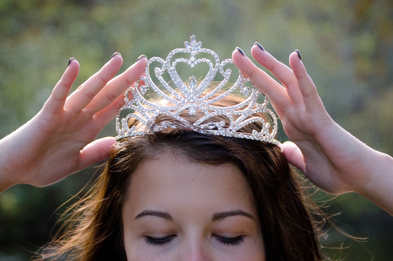 Woman putting on a tiara.