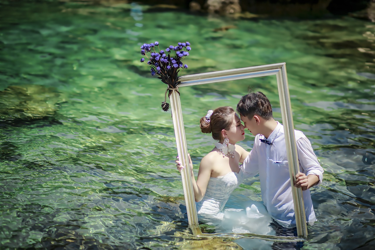 Bride and groom standing in a stream.