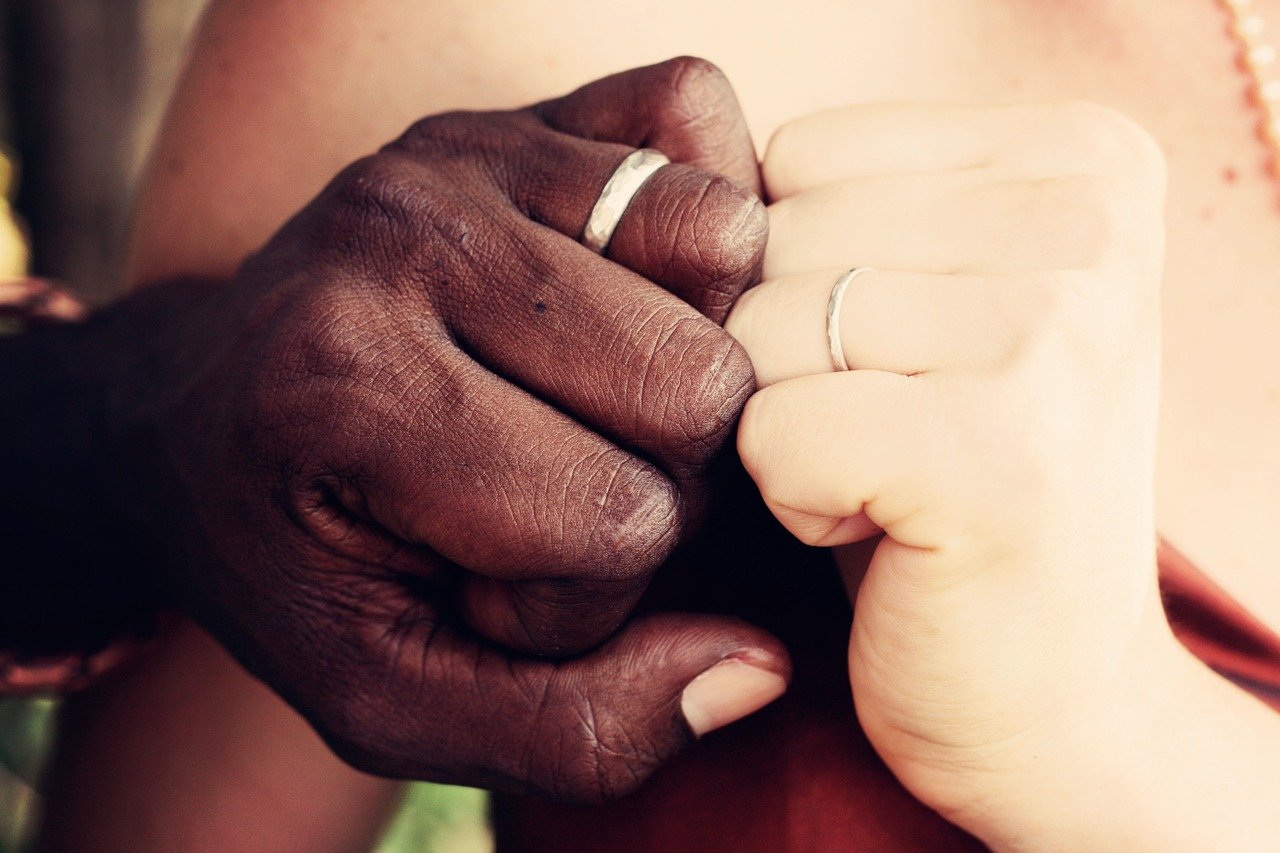A couple wearing wedding bands.